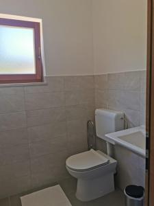 baño con aseo y lavabo y ventana en Apartman Kneže, en Korčula