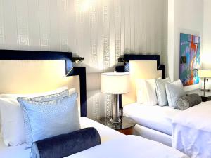 - une chambre avec deux lits et une table avec une lampe dans l'établissement MONDRIAN Luxury Suites & Apartments Market Square I, à Varsovie