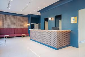 una hall con pareti blu e un bar con panche rosse di Hotel Mary a Vico Equense