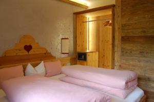 1 dormitorio con 1 cama con sábanas rosas en Hotel Schweizerhof, en Oberau