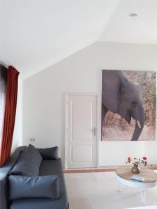 uma sala de estar com um sofá e uma fotografia de um elefante em Bed & Breakfast Trouwborst em Rhenen