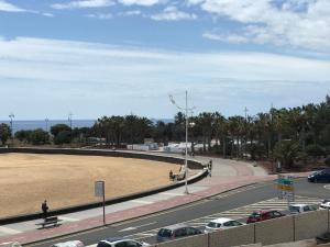 uma estrada com um grande campo ao lado de um parque de estacionamento em Casa City em Arrecife