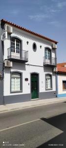 un edificio bianco con una porta verde su una strada di Hospedaria Os Condes a Reguengos de Monsaraz