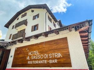 um edifício com uma placa que lê hotel aascoped estirpe bar pré-histórico em Hotel Al Sasso di Stria em Andraz