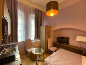 1 dormitorio con cama, mesa y lavamanos en Pension Jeske Heidelberg, en Heidelberg