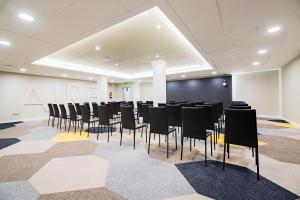 une salle de conférence avec des chaises noires et un mur dans l'établissement Golden Hotel Barcelona, à Barcelone