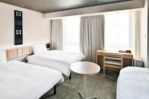 A bed or beds in a room at REF Matsuyama City Station by VESSEL HOTELS