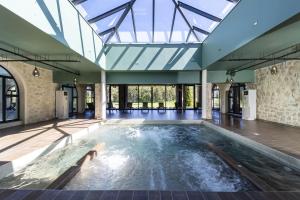 una piscina cubierta con techo de cristal en Château et Golf De Taulane, en La Martre