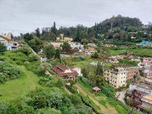 une ville sur une colline avec des maisons et des arbres dans l'établissement Astoria Residency, à Ooty