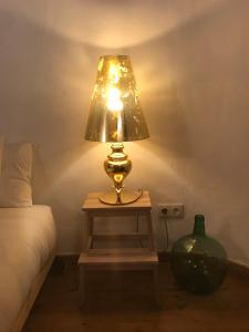 a lamp sitting on a table next to a bed at Azeite de Marvão, Olivoturismo casa Venda do Lagar in Marvão