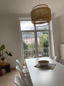 a dining room with a table and a large window at Au bord de l'Ourthe in La Roche-en-Ardenne