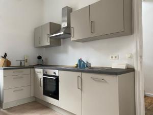 a kitchen with white cabinets and a stove top oven at Au bord de l'Ourthe in La Roche-en-Ardenne