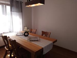 comedor con mesa de madera y sillas en Apartamenty Kletówka, en Krosno