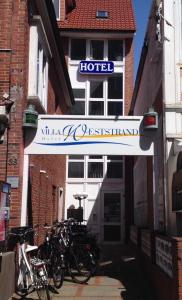 un grupo de bicicletas estacionadas frente a un hotel en Hotel Villa Weststrand, en Borkum