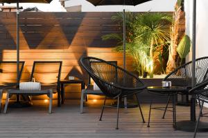 - un ensemble de chaises et de tables sur une terrasse dans l'établissement Elite Hotel - Gay Men Only, à Sitges