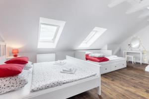 - une chambre blanche avec 2 lits et un miroir dans l'établissement Penzion Belle Donne, à Znojmo