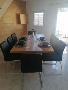 - une table à manger avec des chaises et une table en bois dans l'établissement Gîte L'âme Du Gourmand, à Pontorson