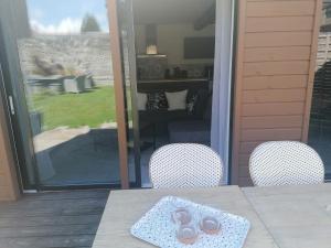 - une table avec 2 chaises sur la terrasse dans l'établissement Gîte L'âme Du Gourmand, à Pontorson