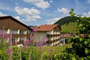 een uitzicht op een resort met paarse bloemen bij Interest Vitalhotel - Partnerbetrieb von Oberstaufen PLUS in Oberstaufen