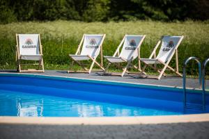 3 sedie a sdraio sedute accanto alla piscina di Gawra Comfort+ a Lesko