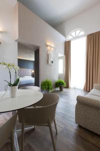 ein Wohnzimmer mit einem Tisch und einem Bett in der Unterkunft Hotel Al Campanile - Luxury Suites & Apartments in Baveno