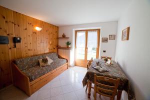 ein Wohnzimmer mit einem Sofa und einem Tisch in der Unterkunft Chalet Bucaneve in Santa Caterina Valfurva