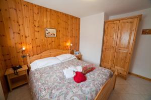 ein Schlafzimmer mit einem Bett mit einem roten Kissen darauf in der Unterkunft Chalet Bucaneve in Santa Caterina Valfurva