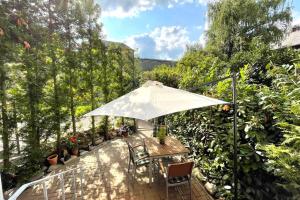 a patio with a table and an umbrella at Villa Einhorn: Altstadt Loft mit privater Terrasse in Goslar