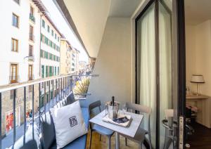 einen Balkon mit einem Tisch und Blick auf ein Gebäude in der Unterkunft Hotel della Signoria in Florenz