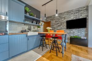 a kitchen with blue cabinets and a table with stools at Apartment ERAK HILL in Zlatibor