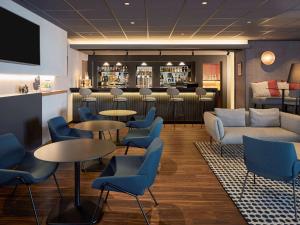 una hall con tavoli e sedie e un bar di Novotel Massy Palaiseau a Palaiseau