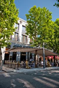 um restaurante com mesas e cadeiras em frente a um edifício em Hotel Hemera em Podgorica