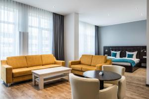 - un salon avec un canapé et un lit dans l'établissement RheinCity Hotel & Boardinghouse, à Ludwigshafen