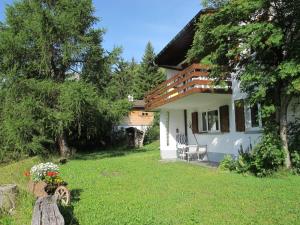 ein kleines weißes Haus mit einer Veranda und einem Hof in der Unterkunft Haus Tgamotsch***- Ferienwohnung in Valbella in Valbella