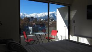 Schlafzimmer mit Blick auf einen Balkon mit einem Tisch und Stühlen in der Unterkunft Heidelberg Haus Apart Hotel in Santiago