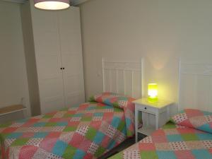 เตียงในห้องที่ Apartamentos El Pinedo