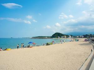 um grupo de pessoas em uma praia com o oceano em Seaside Minbak em Goseong