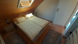 um pequeno quarto com uma cama no sótão em Pátri Apartmanház em Keszthely