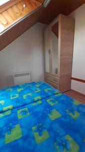 um quarto com uma cama azul com lençóis azuis e um armário em Pátri Apartmanház em Keszthely