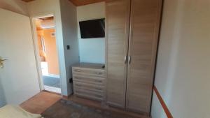 um quarto com uma cómoda e uma televisão em Pátri Apartmanház em Keszthely