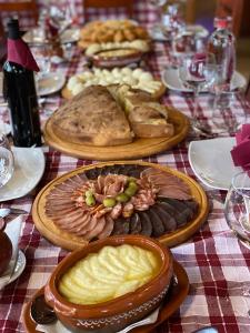 una mesa cubierta con platos de comida en una mesa en Hotel Pavlović, en Žabljak