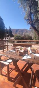 uma mesa de piquenique de madeira com tigelas em cima em Hosteria La Estacion em Tilcara