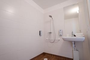 y baño blanco con lavabo y ducha. en Kyriad Cholet, en Cholet