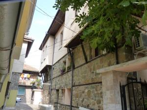 an alley in an old stone building with a tree at Guest House Zhelevi in Sozopol