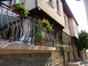 a balcony with potted plants on the side of a building at Guest House Zhelevi in Sozopol