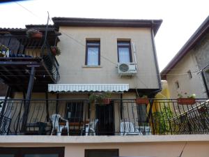 a building with a balcony with chairs and an air conditioner at Guest House Zhelevi in Sozopol