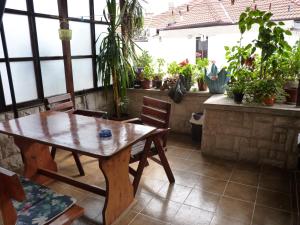 a wooden table and chairs in a room with potted plants at Guest House Zhelevi in Sozopol