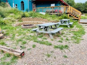 Deux tables de pique-nique dans l'herbe devant un bâtiment dans l'établissement Cloudcroft Hostel, à Cloudcroft