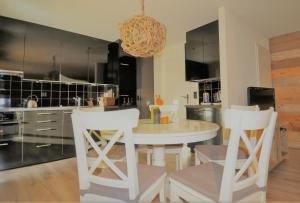 a kitchen with a white table and white chairs at Romatika 2 in Fiesch