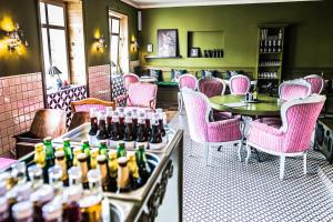 un restaurante con sillas rosas y botellas de cerveza en Boutique Hotel Massimos, en Námestovo